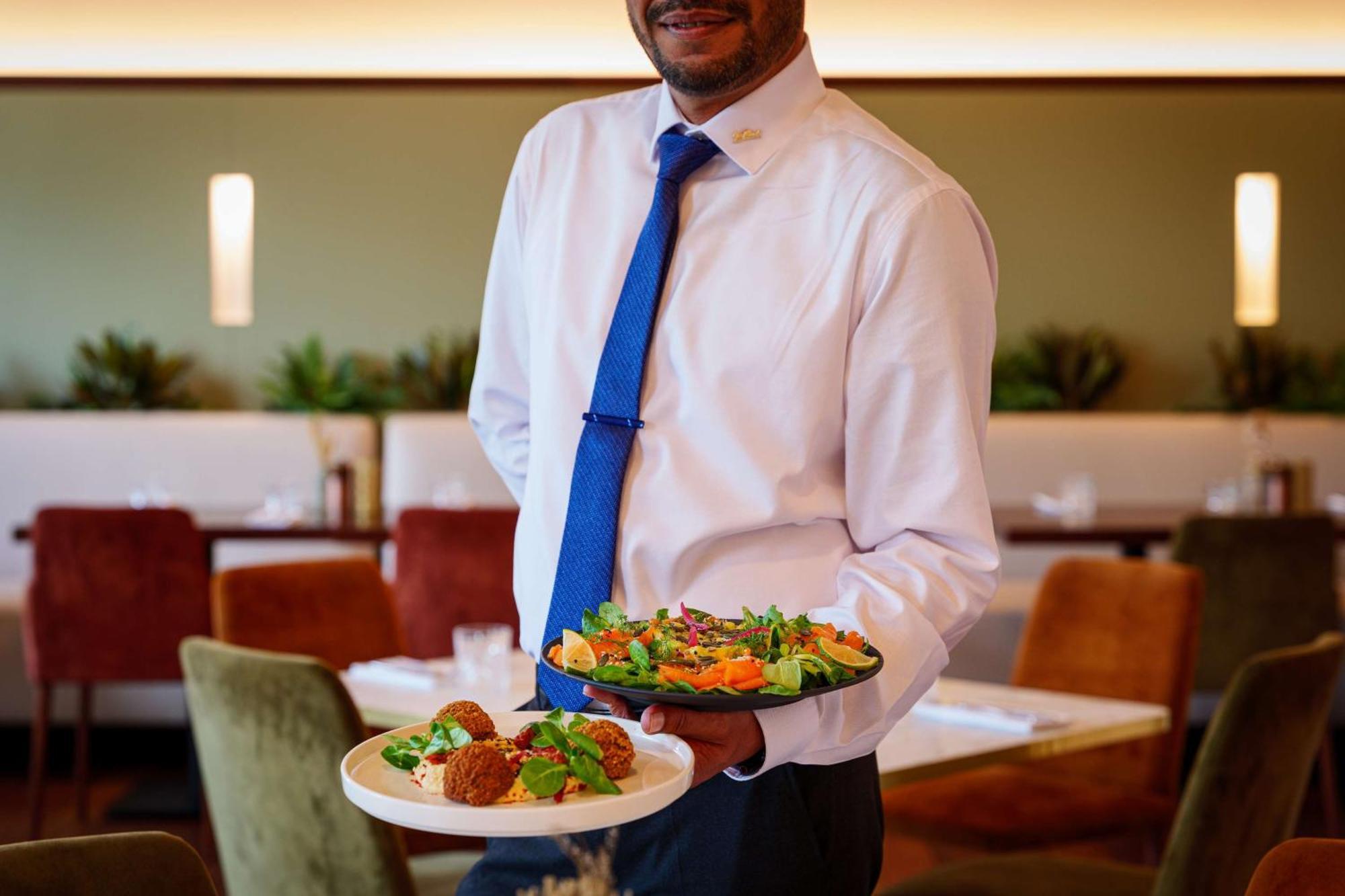 Radisson Blu Hotel Paris, Marne-la-Vallée Magny-le-Hongre Exterior foto Waiter holding plate of food